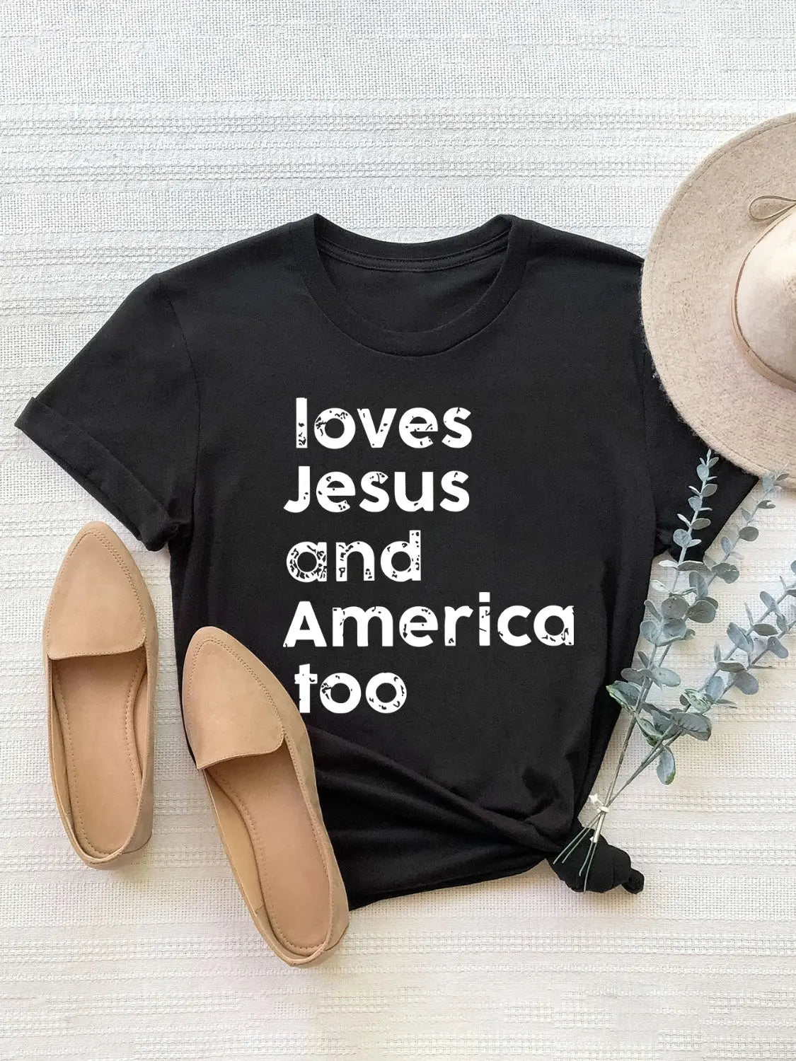 Flat Lay Black Loving Jesus and America Round Neck Short Sleeve T-Shirt with bold patriotic design, soft fabric, and flattering fit for everyday style.