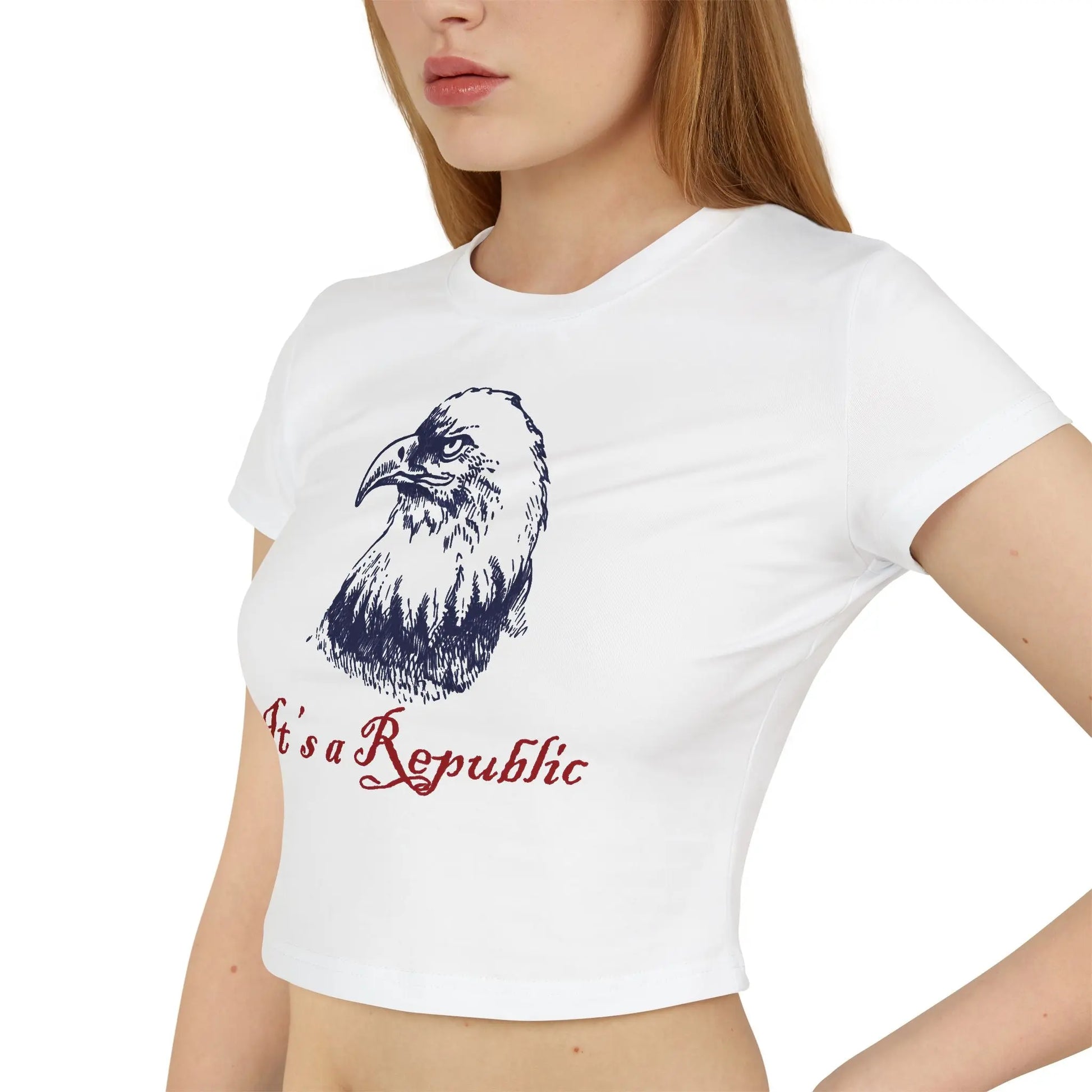 Close up of white baby tee crop top with eagle design and "It's A Republic" text worn by a lady with red hair.