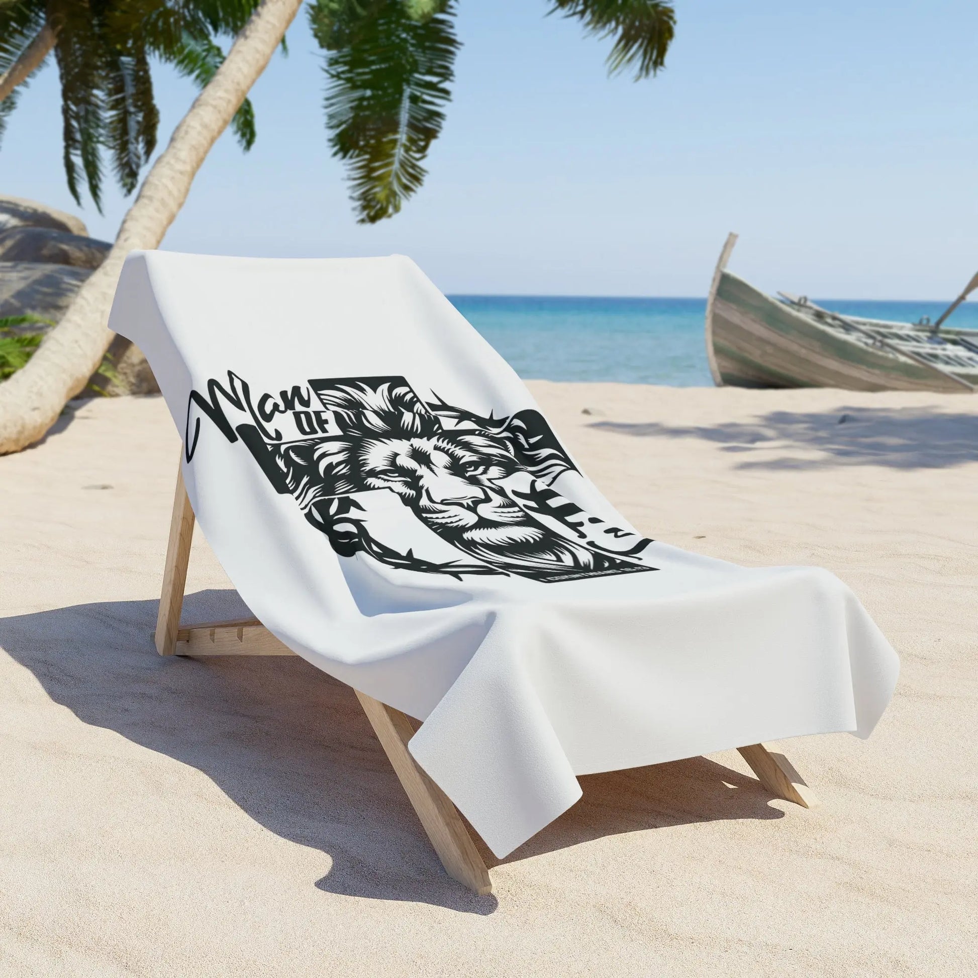 A beach chair with a white towel featuring a lion, cross, and 'Man of Faith' in black and white.