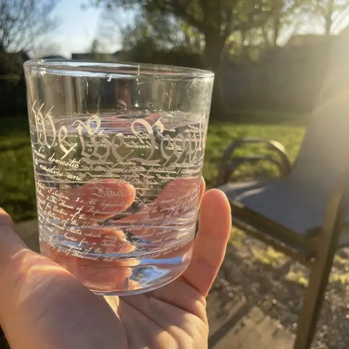 Hand holding 12oz U.S. Constitution Whisky Glass with detailed engraving, perfect for whiskey lovers and history enthusiasts.