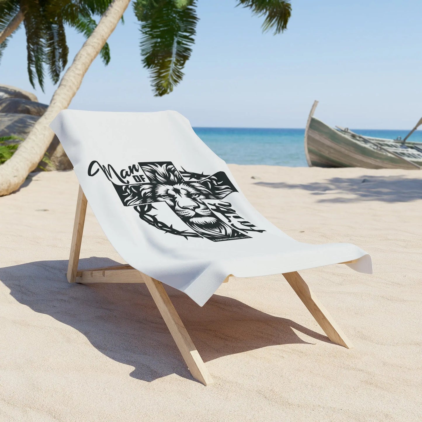 A beach chair with a white towel featuring a lion, cross, and 'Man of Faith' in black and white.