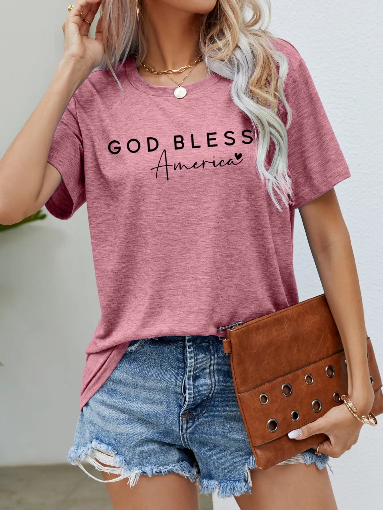 Dusty Rose God Bless America Graphic Short Sleeve Tee with bold patriotic design, breathable fabric, and a comfortable fit for stylish everyday wear.