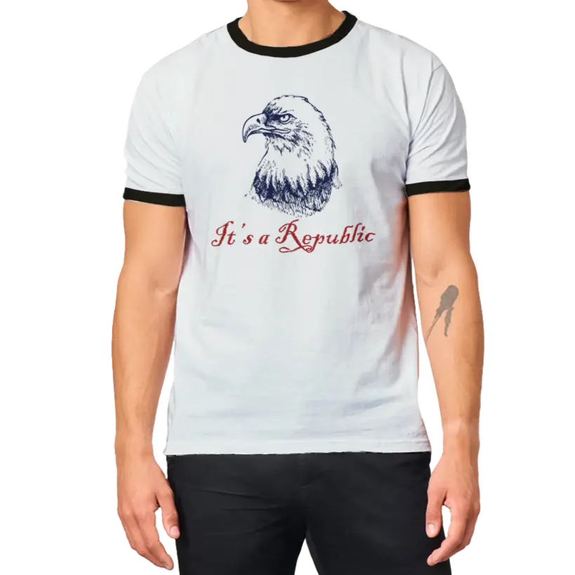 Man wearing White shirt with black trim on neck and short sleeve cuffs with an eagle and text It's A Republic. Envy The Eagle Design