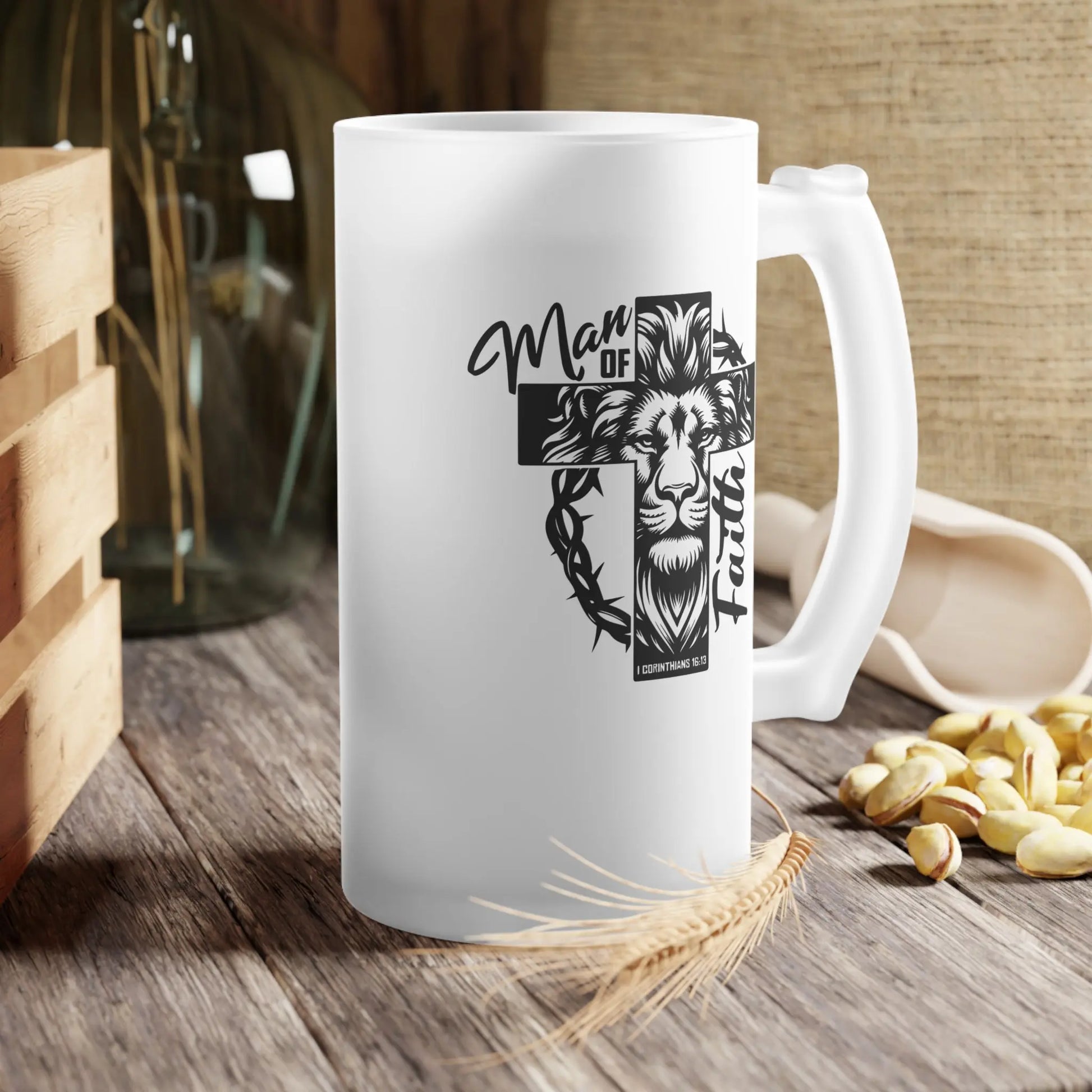 16oz frosted glass mug with lion, cross, and 'Man of Faith' text in black and white on a table.