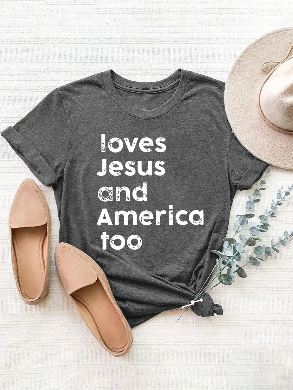 Flat Lay Loving Jesus and America Round Neck Short Sleeve T-Shirt with bold patriotic design, soft fabric, and flattering fit for everyday style.